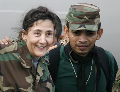 Vemos a una mujer con traje militar camuflado que es ayudada por  otro militar