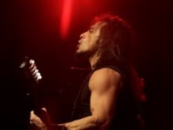 Un músico de pelo largo interpreta su guitarra en un concierto