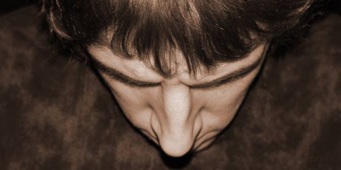 Un primer plano de la cara mirando hacia abajo de un joven muy triste