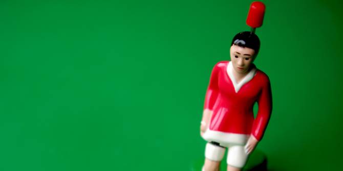 Una figura humana plastica de juguete con un pin atravesando su espalda