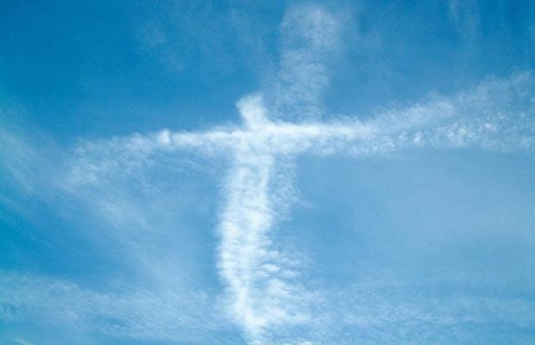 Tenemos un cielo azul y unas nubes blancas  que forman una figura de jesus en la cruz