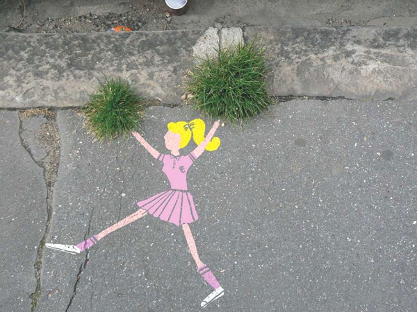 Vemos una pared de cemento donde observamos a una niña con traje rosado pintada ahí que sobresale un par de plantas que hace las veces de pompones 