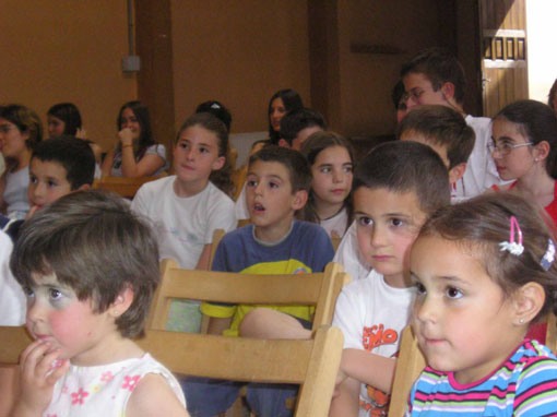 Vemos un aula de clase donde vemos niños y niñas atentos a su clase