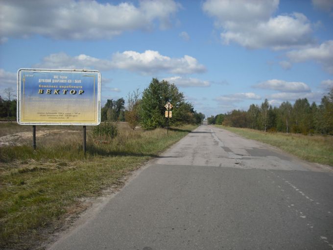 Vemos una carretera con arboles y unos carteles que dicen algo en otro idioma