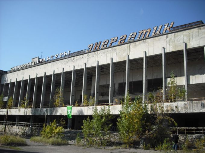 Vemos una edificación no muy destruida grande y blanca y también mucha vegetación se ve