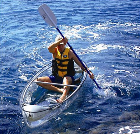 Tenemos aun hombre con chaleco salvavidas que rema  en una canoa transparente
