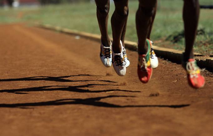Vemos tres pares de zapatos de atletas que entrenan en campos de entrenamiento