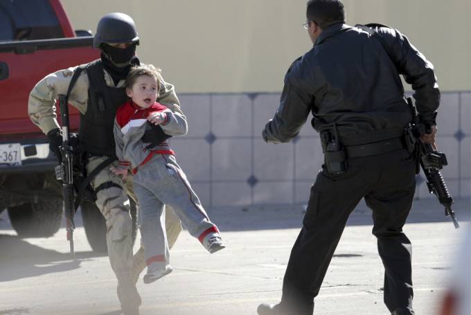 vemos a un niño cargado por un militar que lo saca de un lugar peligroso