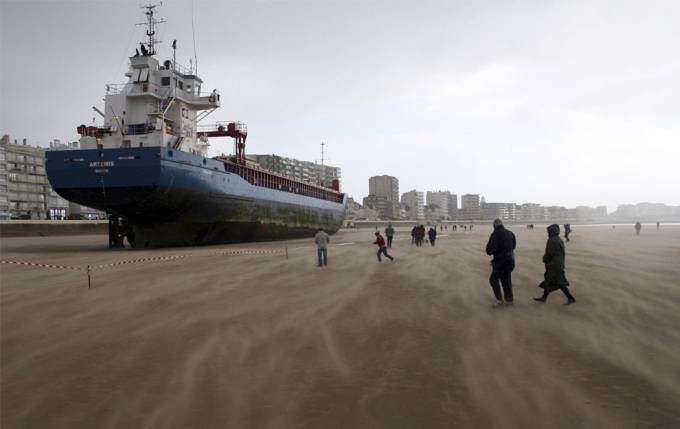 Vemos un barco que encallo en la arena y muchas personas van a verlo