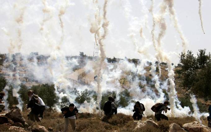 Vemos mucho humo my personas con mascaras sentadas en el suelo