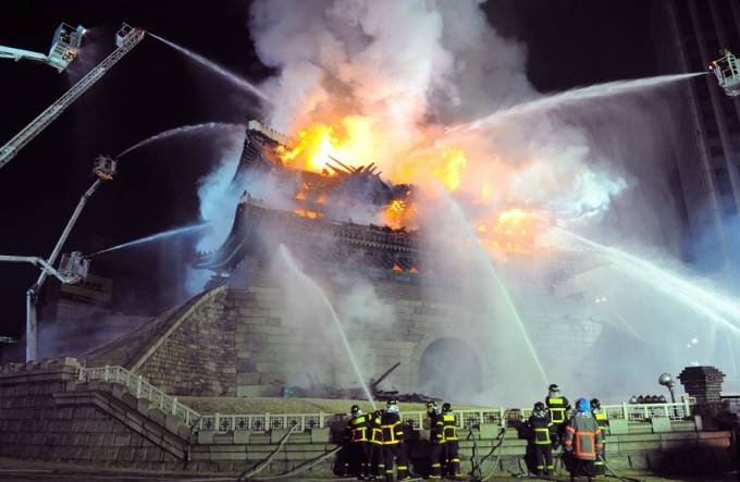 Vemos un gran incendio de una muy grande construcción donde los bomberos luchan con terminar el fuego con largas escaleras