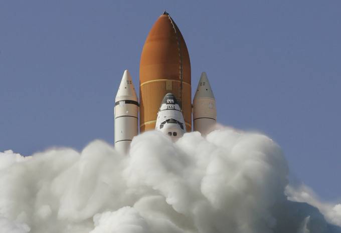 Vemos al transbordar espacial discovery que sale en misión espacial en medio de una cantidad de humo