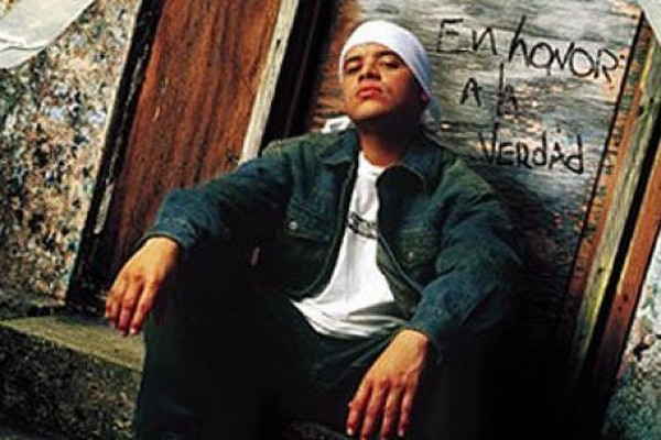 Un muchacho con un gorro en la cabeza sentado esperando par a irse y unas palabras sobre una puerta