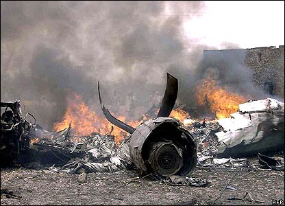 Un avión siniestrado yace en tierra con su  fuselaje en llamas  