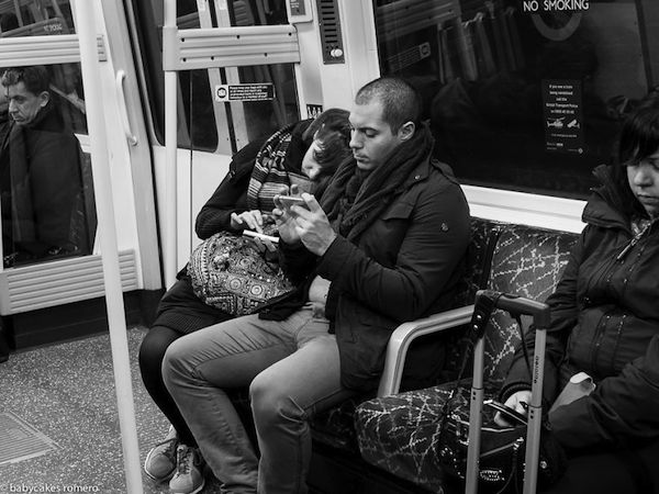 Veo a una pareja dentro del metro cada uno observa su celular  se ven mas personas allí  adentro