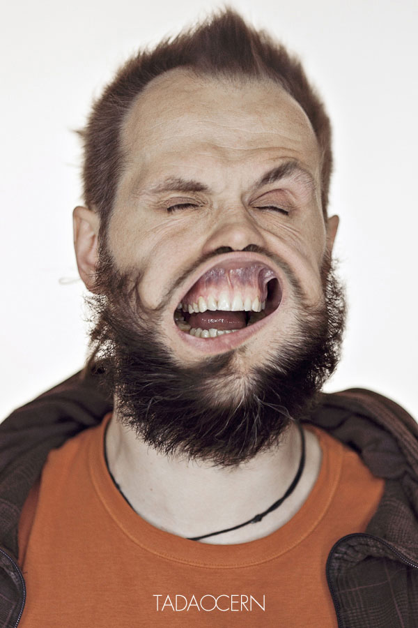 Un hombre con su pelo hacia arriba sus ojos cerrados  su boca abierta deja ver sus encías y dientes la boca se estiende un poco hacia abajodi