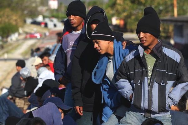 varios hombres muy jóvenes esperan algo para continuar la marcha