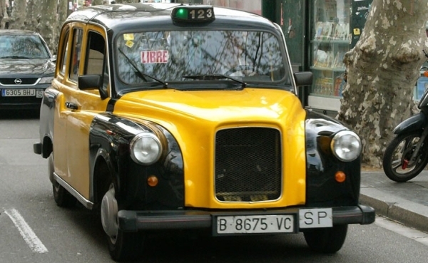 Tenemos un carro pequeño amarillo con negro muy limpio y cuidado con un aviso de libre y avanza por la calle 