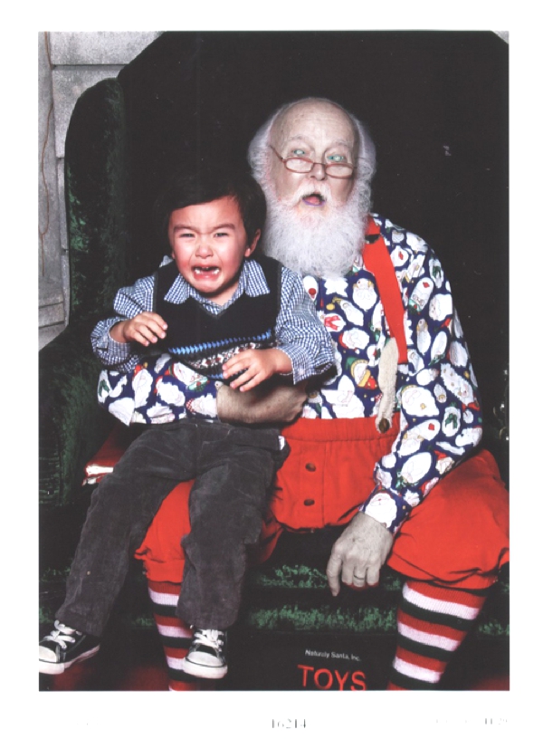 Un lindo niño en el regazo de Santa Claus LLora no quiere estar ahi
